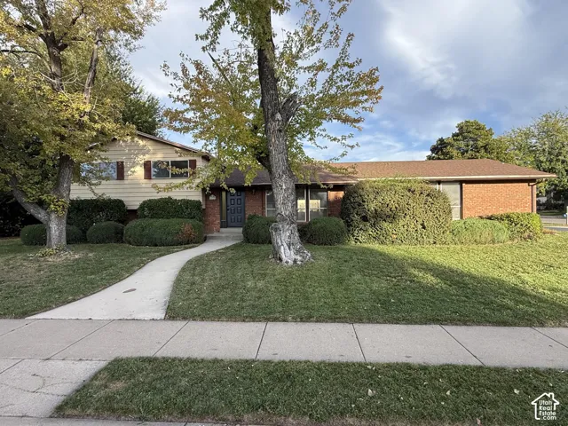 Exterior featuring brick siding, horizontal paneling, and a gabled roofline
