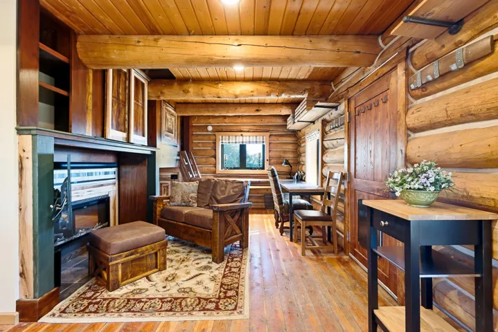 Wood-paneled ceilings, natural wood walls, wood-finish flooring, built-in shelving, and a built-in fireplace