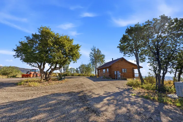 Log-sided exterior with an attached deck and a metal roof