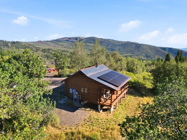 Log cabin exterior with a metal roof and solar panels