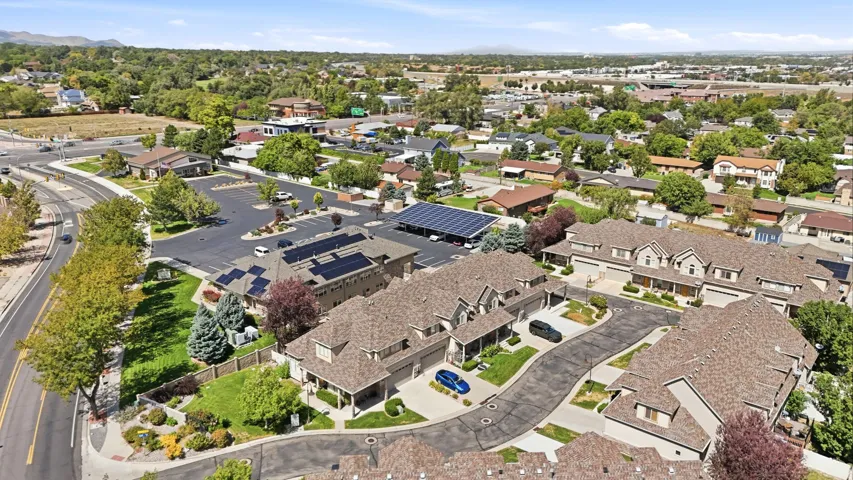 Townhome community with multiple residential structures, pitched shingle roofs, and attached garages