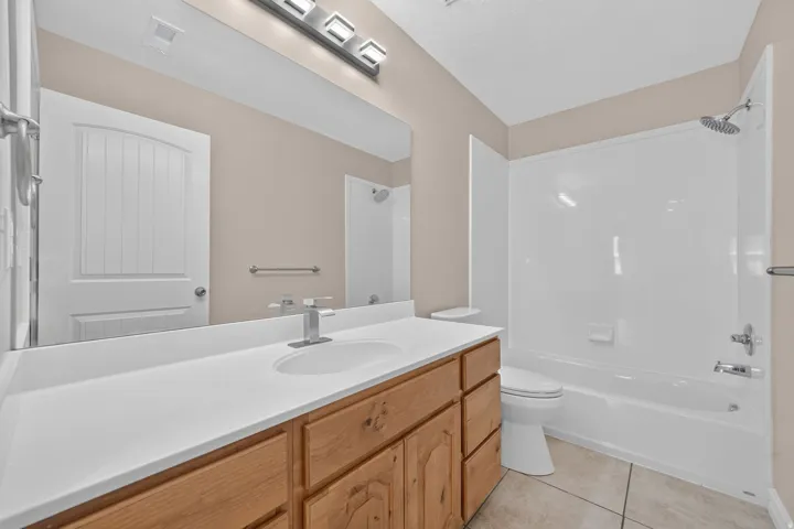 Vanity with light wood-finish cabinetry and white countertop
