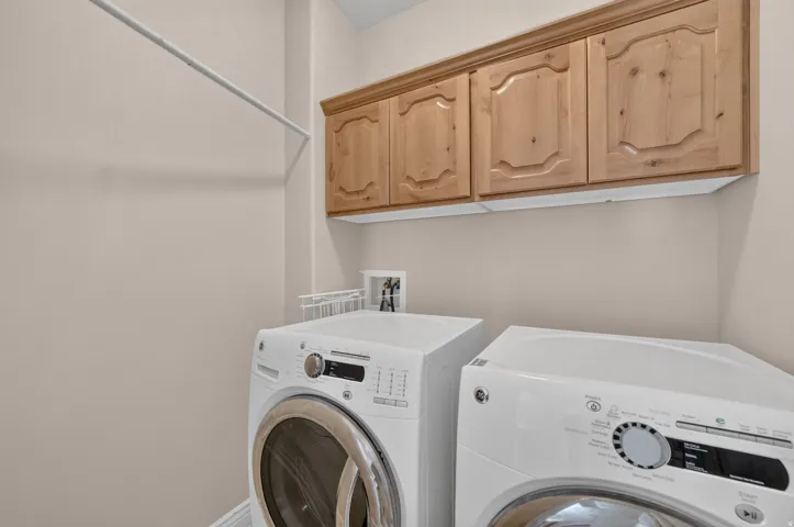 Upper cabinetry with panel detailing and a hanging rod