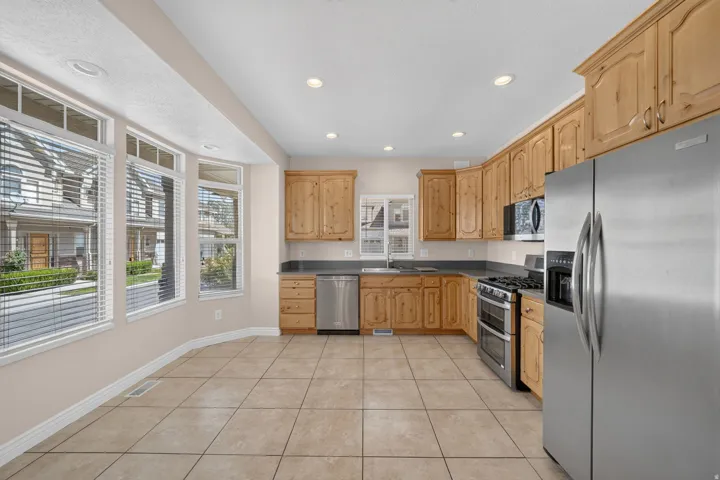 Kitchen featuring wood cabinetry, stainless steel appliances, and a gas range