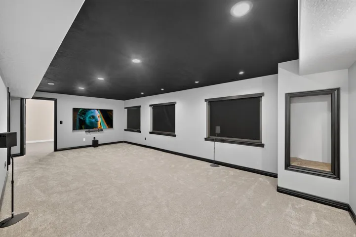 Expansive room featuring recessed lighting, a dark-toned ceiling, light-toned walls, and plush carpet flooring