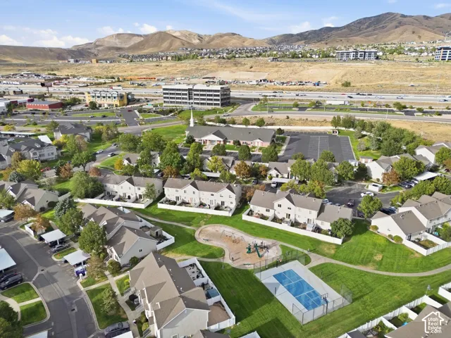 Community green space featuring a playground, multi-sport court, and paved walking paths