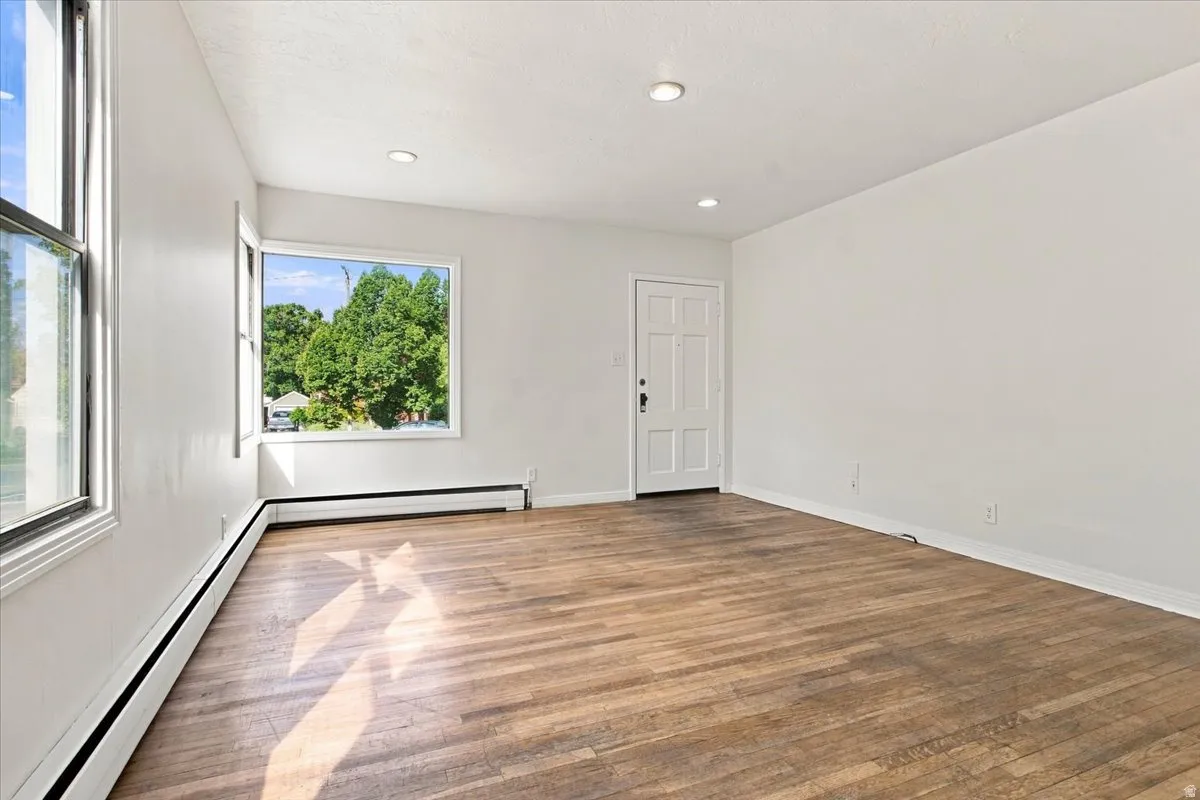 Wood-finish flooring, recessed ceiling lighting, and multiple windows