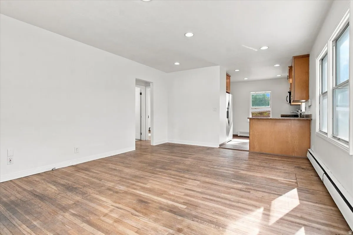 Wood-finish flooring, recessed lighting, and white walls