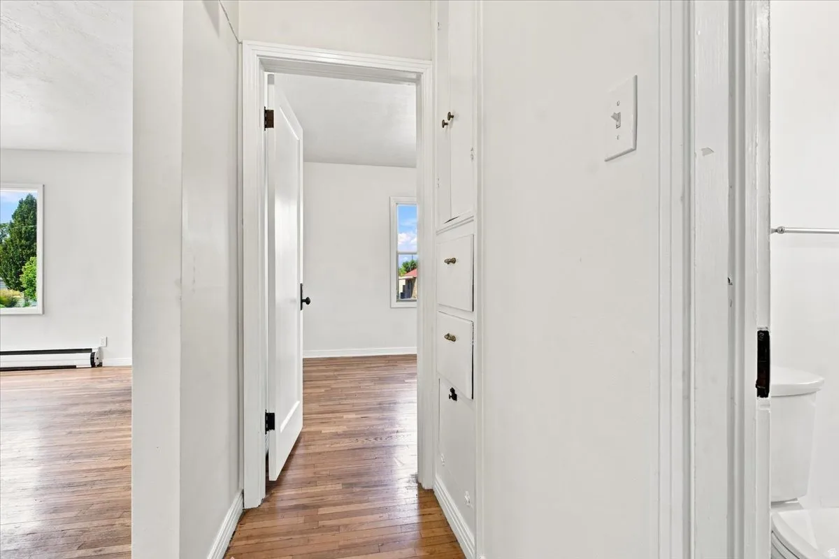 Wood-finish flooring throughout, white painted walls, and built-in storage cabinetry