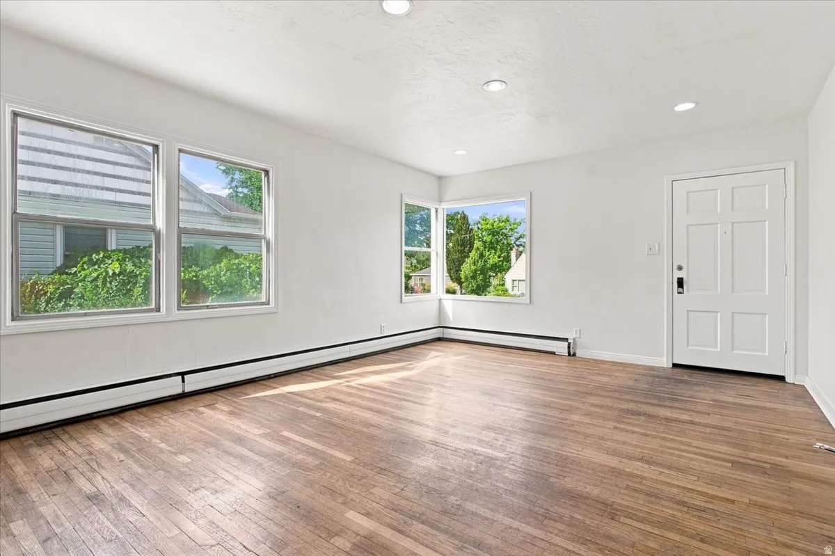Hardwood flooring, recessed lighting, multiple windows, and a panel entry door