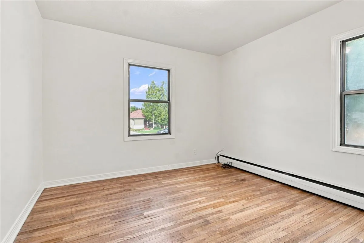 Hardwood flooring, painted white walls, and bright windows