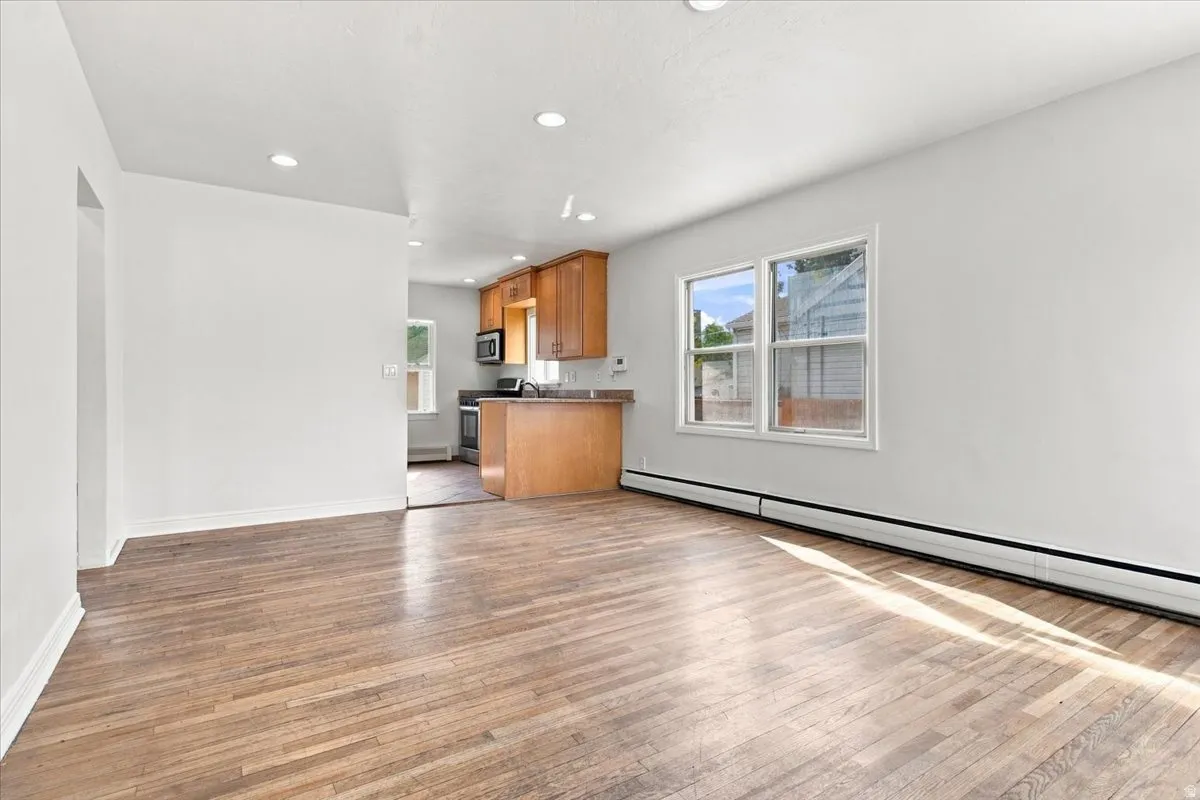 Wood-finish flooring, recessed lighting, double-pane windows, and light neutral wall finishes