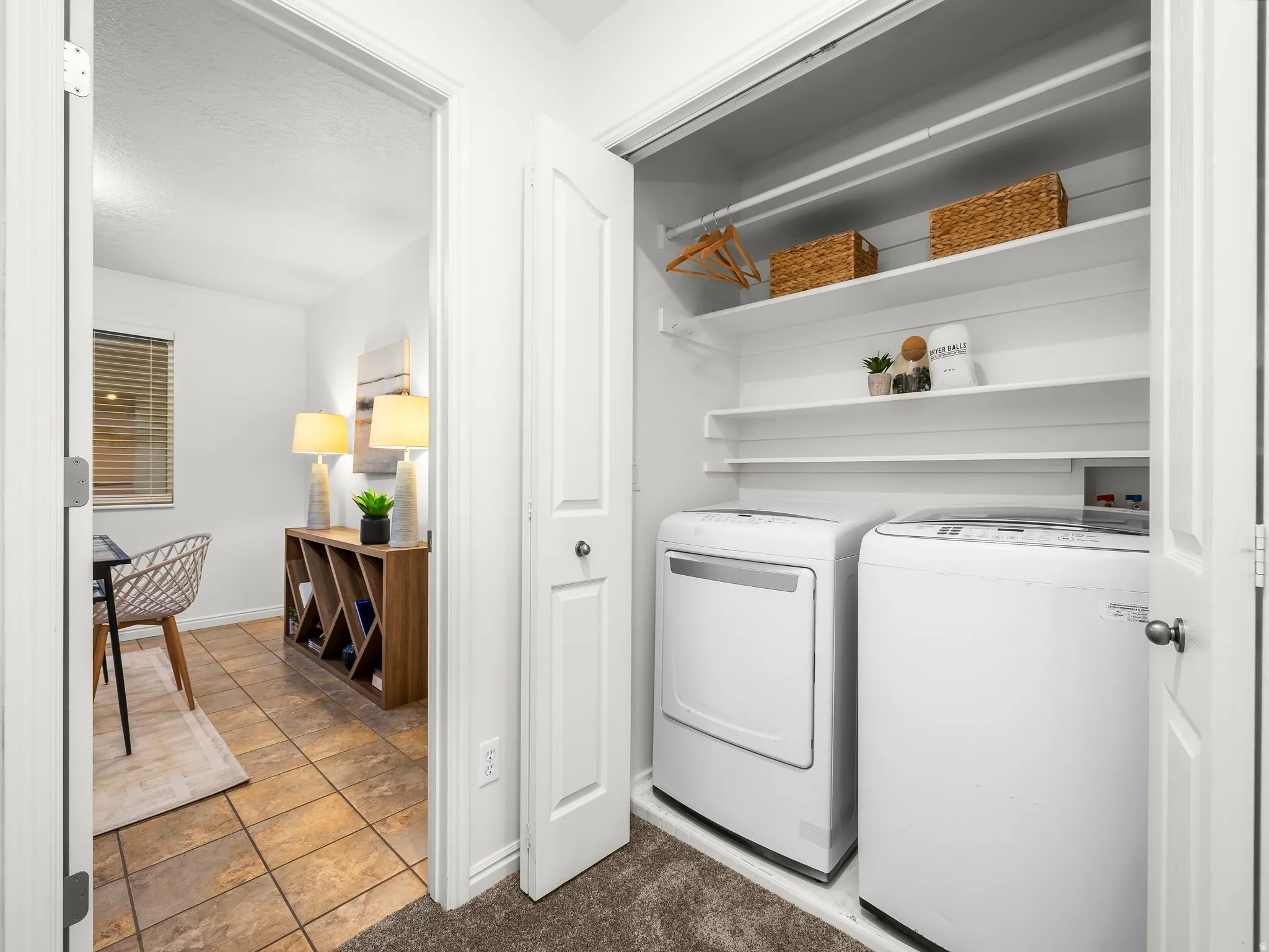 Integrated laundry closet with shelving above included washer and dryer.