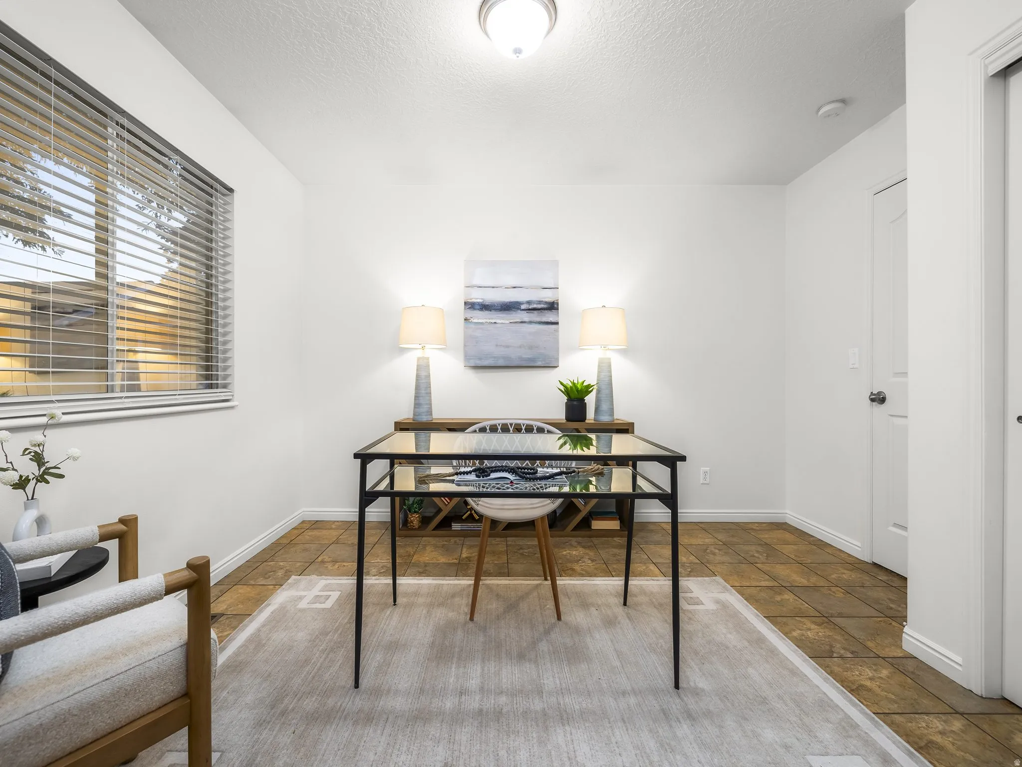 Tiled flooring, white painted walls, window with horizontal blinds, and built-in closet.