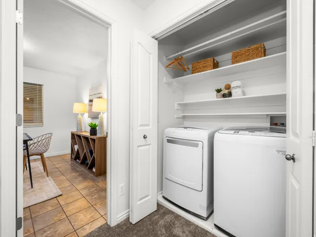 Integrated laundry closet with shelving above included washer and dryer.