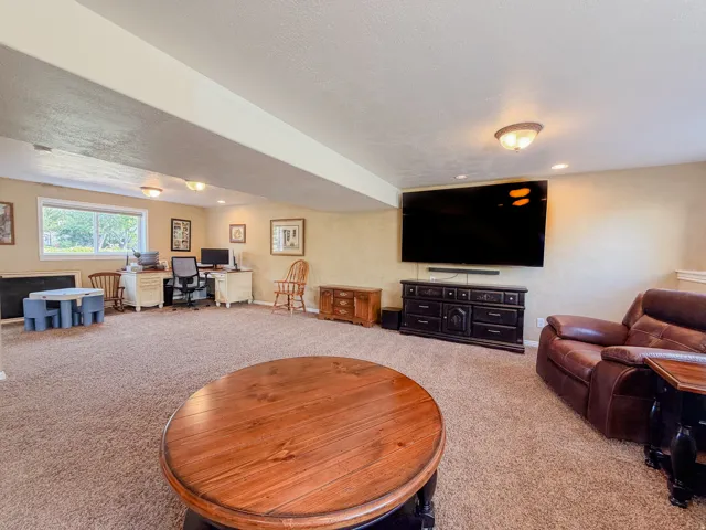Spacious room featuring neutral carpeting, recessed lighting, and a large window