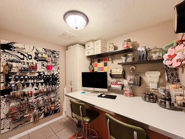 Recessed ceiling lighting, built-in white cabinetry, wall-mounted shelving, and a long built-in desk surface