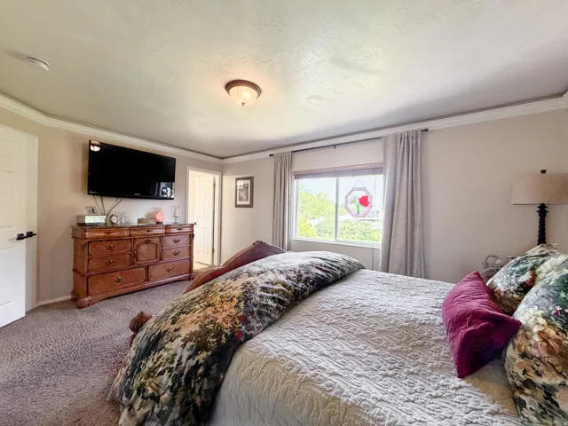 Crown molding accents the ceiling, a window allows natural light, and a built-in light fixture provides illumination