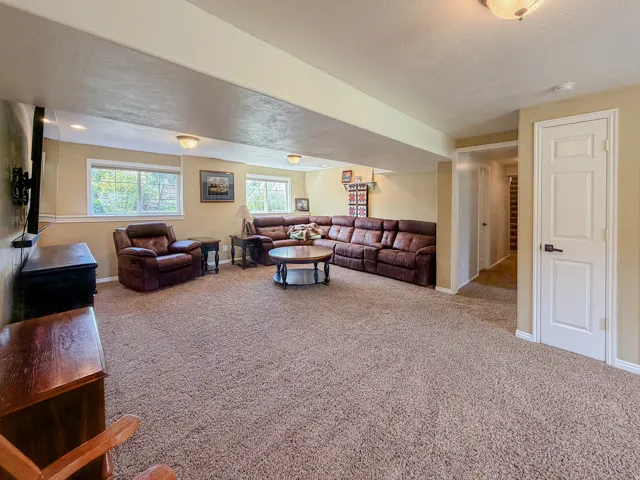 Generous room proportions with carpet flooring, recessed lighting, and multiple windows providing natural illumination