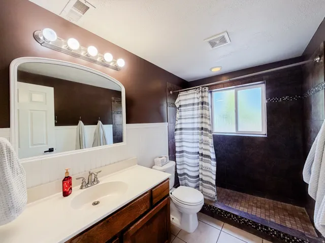 Vanity with an integrated sink, brushed nickel faucet, and a large framed mirror
