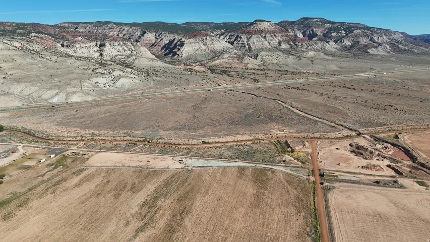 Expansive land parcel with mountainous terrain, visible roadways, and open fields