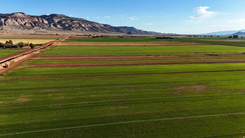 Expansive agricultural fields with distant mountain ranges and a clear blue sky