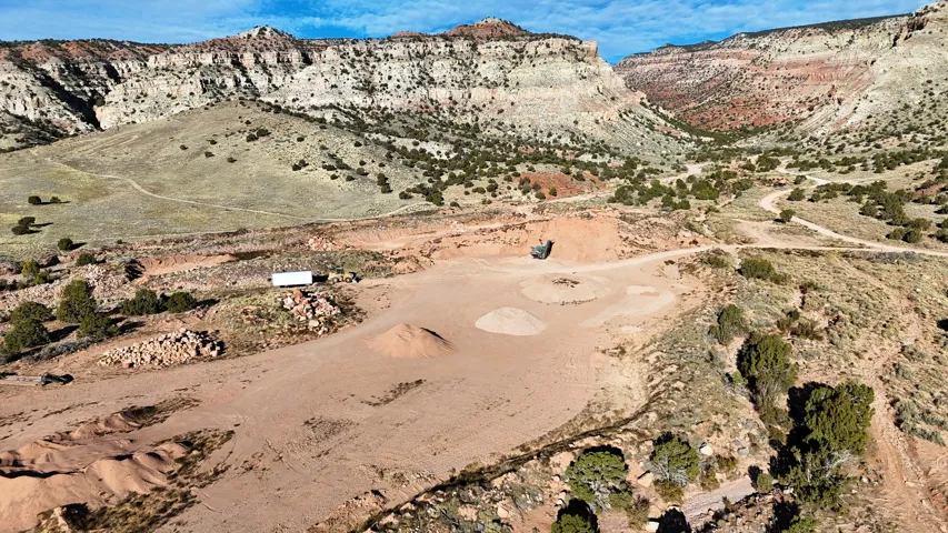 Expansive lot with a mountainous backdrop, featuring a flat, cleared area and natural terrain