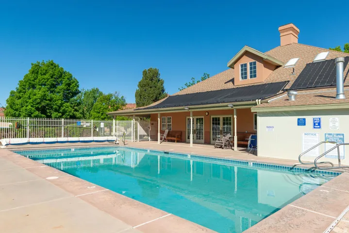 Outdoor swimming pool with integrated entry steps and perimeter fencing