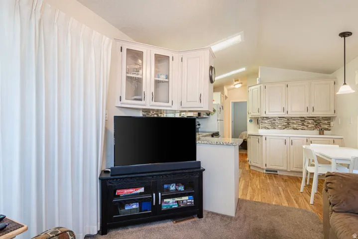 Kitchen featuring light cabinetry, tile backsplash, and light countertops