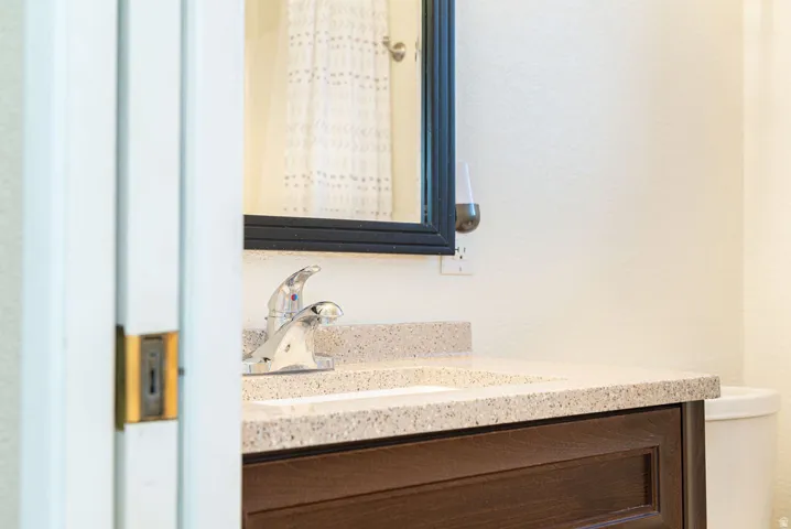 Vanity with an integrated sink, polished chrome faucet, and dark wood-finish cabinetry