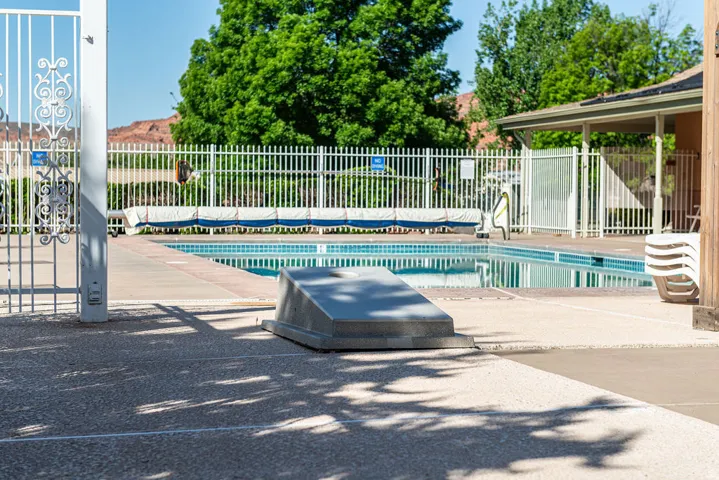 Gated swimming pool with surrounding concrete decking