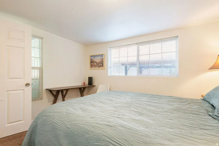 Bright interior with neutral-toned walls, a white paneled door, and a large window with blinds