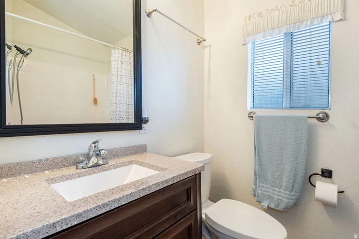 Vanity with a built-in sink, dark wood-finish cabinetry, and a speckled countertop