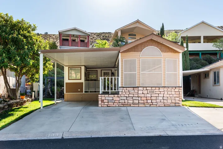 Exterior featuring a covered carport, stone façade accents, and an arched window