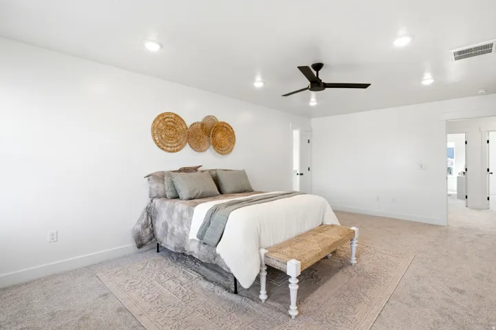 Recessed lighting, ceiling fan, white walls, and light-colored carpeting