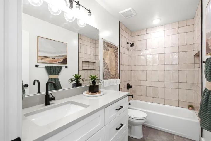 Built-in vanity with a single basin sink, matte black faucet, and white cabinetry