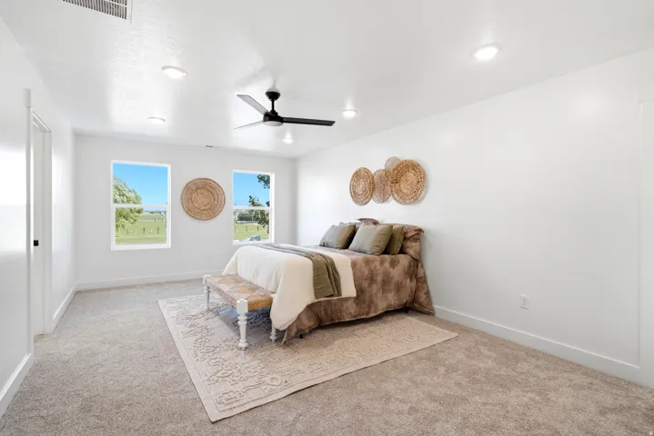 Carpeted flooring, recessed lighting, ceiling fan, and two windows