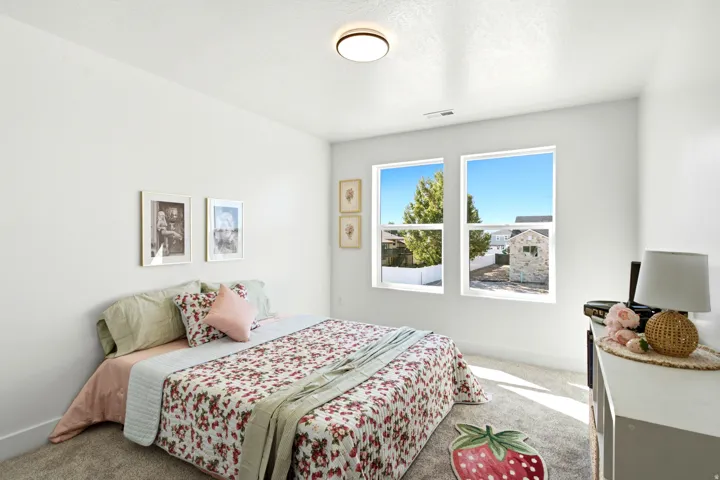 White painted walls, two large windows, flush mount ceiling light, and light-colored carpeting