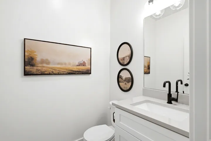 White vanity with a neutral countertop, undermount sink, and matte black faucet