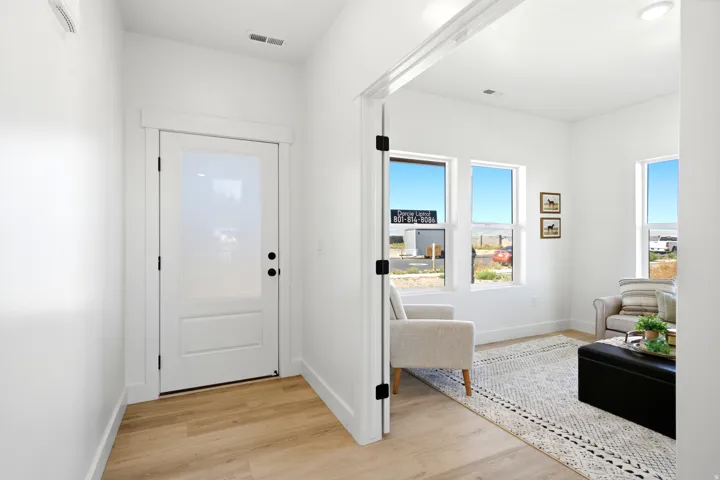 Entryway with wood-finish flooring and a white door featuring a privacy glass panel