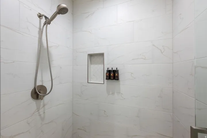 Tiled shower with a handheld showerhead and built-in niche