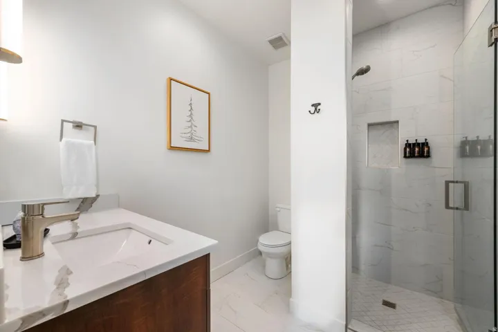 Bathroom featuring a dark wood-finish vanity with a white countertop, undermount sink, and brushed nickel faucet