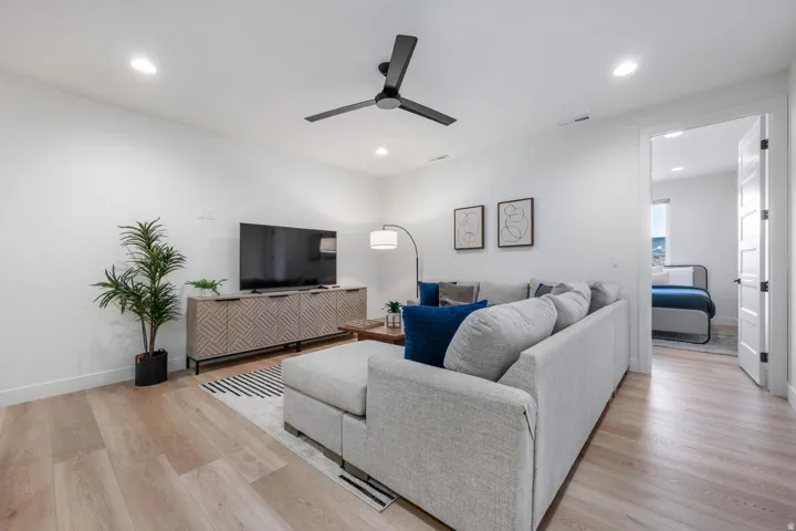 Recessed lighting, wood-finish flooring, and a contemporary ceiling fan