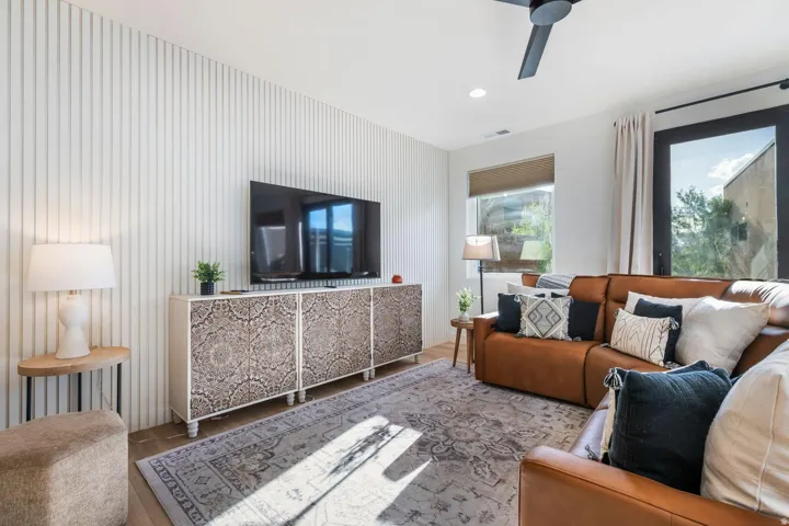Fluted accent wall, recessed lighting, and a modern ceiling fan