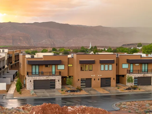 Contemporary architecture with stucco exteriors, stone accents, and integrated garages