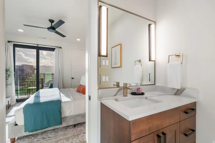 Built-in vanity with a single basin sink, light-toned countertop, and wood-finish cabinetry