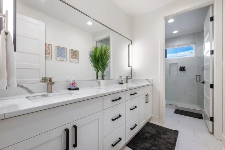 White double vanity with integrated sinks, brushed nickel faucets, and black hardware