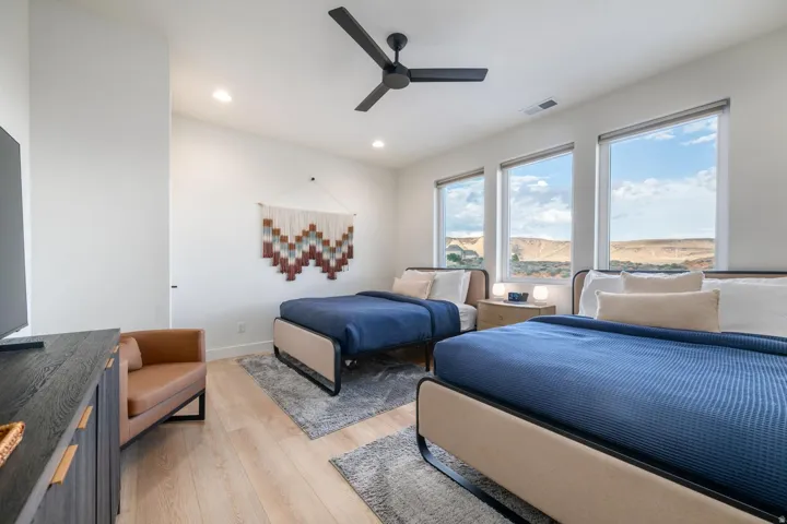 Light wood-finish flooring, recessed lighting, and a black ceiling fan