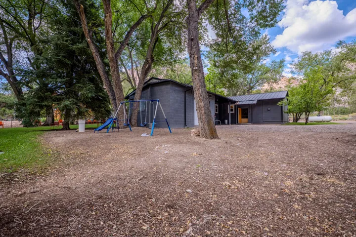 Single-story exterior with a covered entry, dark siding, and a black metal roof