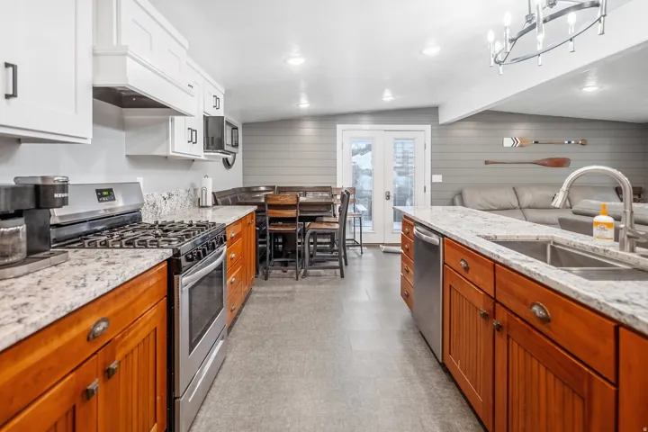 Kitchen featuring wood cabinetry, light-toned countertops, stainless steel appliances, and recessed lighting